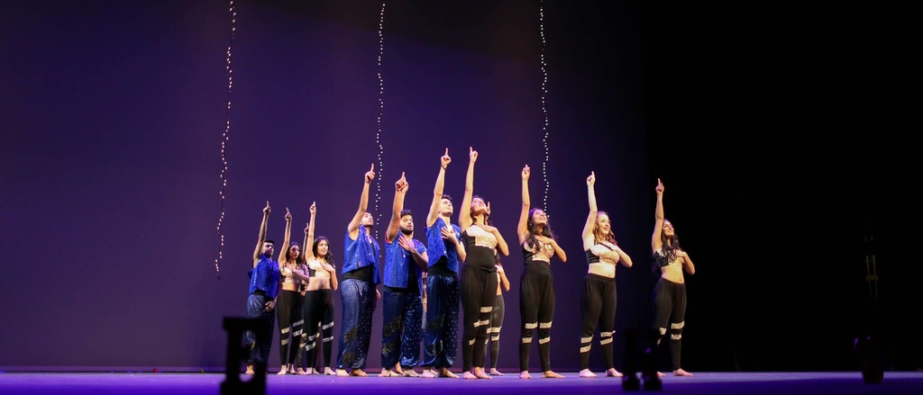 People dancing and pointing on a stage